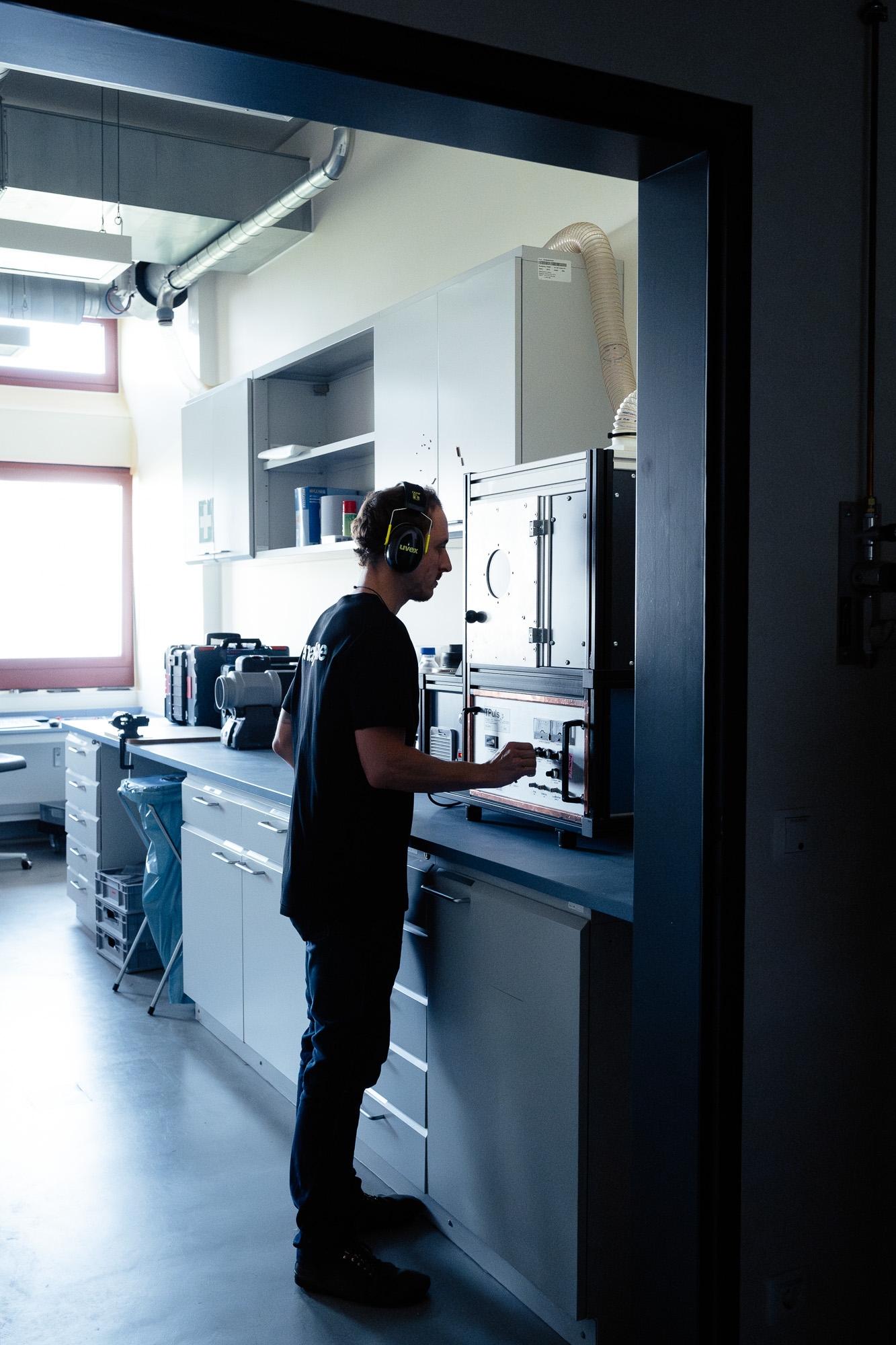 One person precisely operates a device in the laboratory